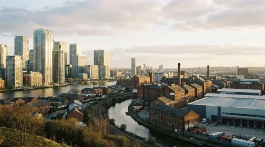 A wide urban landscape photograph comparing contrasting commercial real estate skylines with dramatic natural lighting and architectural detail